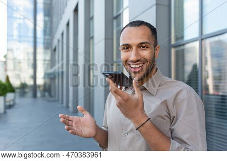 Outdoor Portrait Of Young Smiling African American Man Outside Office Building, Man Recording Audio 