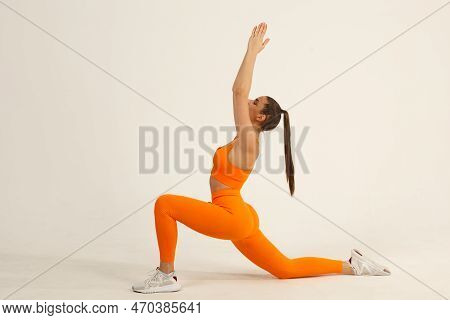Young Positive Smiling Woman Doing Yoga Asana In Orange Fitness Sport Outfit Cloth Studio Isolated S