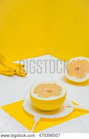 A Citrusy Grapefruit Pomelo On A Plate. Restaurant Room With Yellow Walls