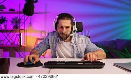 Gamer Bearded Guy, In A Gaming Headset, Wins A Video Game. Cybersportsman In A Neon Room. Lifestyle 