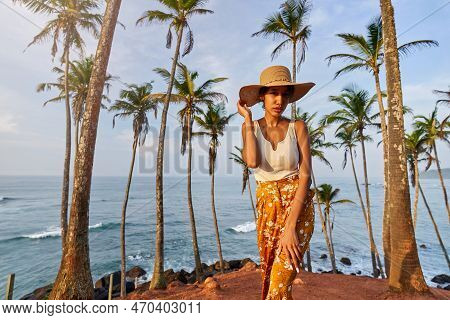 Young African Female Model Posing In Colorful Clothes At Tropical Location At Sunrise. Black Woman A