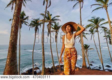 Young African Female Model Posing In Colorful Clothes At Tropical Location At Sunrise. Black Woman A