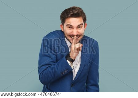 Portrait Of Funny Smiling Handsome Man With Mustache Standing With Finger Near Lips Showing Shh Gest