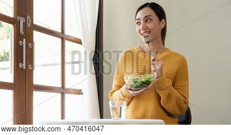 Delighted Woman Eating Food For Health At Home