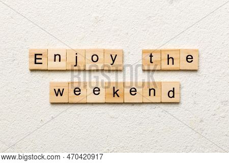 Enjoy The Weekend Word Written On Wood Block. Enjoy The Weekend Text On Cement Table For Your Desing