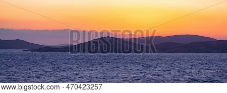 Rocky Island On Mediterranean Sea. Rinia Near Mikonos, Greece, Europe. Nature Background. Sunrise Sk