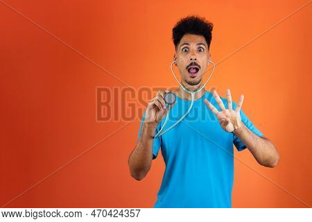 Doctor Or Veterinarian Isolated. Black Young Doctor Medical Resident With Stethoscope On Orange Back
