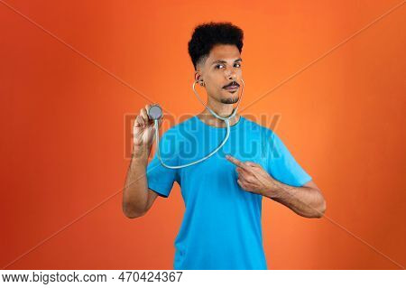 Doctor Or Veterinarian Isolated. Black Young Doctor Medical Resident With Stethoscope On Orange Back