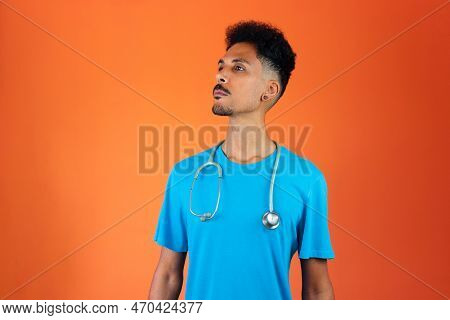 Doctor Or Veterinarian Isolated. Black Young Doctor Medical Resident With Stethoscope On Orange Back