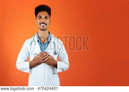 Doctor Or Veterinarian Isolated. Black Young Doctor Medical Resident With Stethoscope On Orange Back