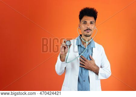 Doctor Or Veterinarian Isolated. Black Young Doctor Medical Resident With Stethoscope On Orange Back