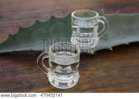 Mexican Tequila Shots And Green Leaf On Wooden Table, Closeup. Drink Made Of Agava