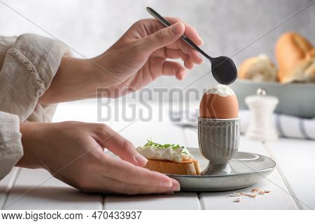 Woman Eating Fresh Soft Boiled Egg At White Wooden Table, Closeup