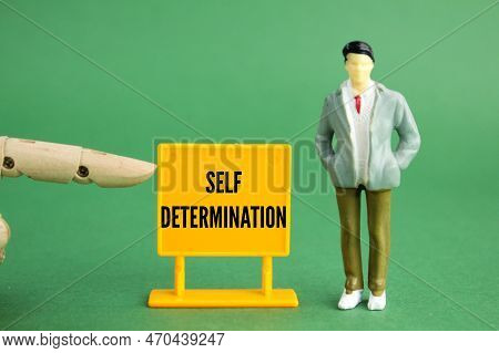 Little People And Plastic Boards With The Word Self-determination. The Concept Of Self-motivation. T