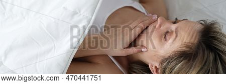 Woman Looks In Shock Under Covers In Bed. Bedwetting In Women Concept