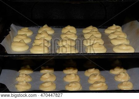 French Cheese Puffs. French Pastry Gougeres On A Baking Sheet In The Oven Before Baking