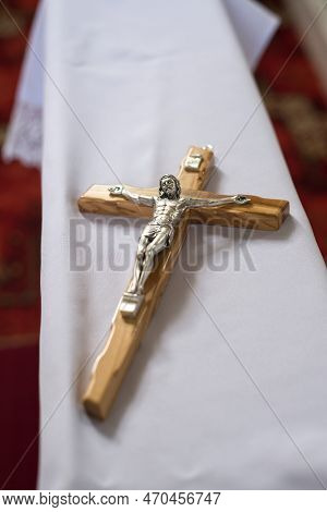 A Small Wooden Cross With Jesus Christ Placed On A Kneeler Before The Wedding