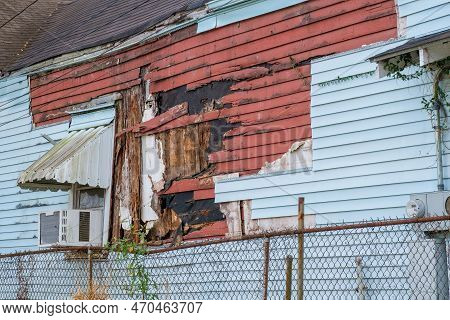 Side View Of Old Home Featuring Two Layers Of Severely Damaged And Rotting Siding, Both Wood And Vin
