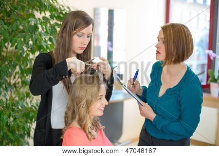 Lærling skære hår, mens instruktøren ser