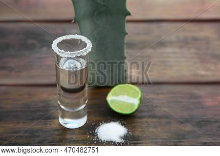Mexican Tequila Shot, Salt, Lime And Green Leaf On Wooden Table, Closeup With Space For Text. Drink 
