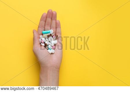 Woman Holding Antidepressants On Yellow Background, Top View. Space For Text