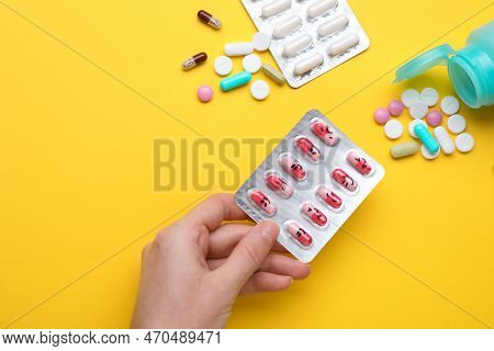 Woman Holding Colorful Antidepressants With Different Emoticons On Yellow Background, Top View