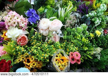 Artificial Flowers And Leaves Displayed On The Wall Of A Store For Sale. Bright Colored Flowers For 