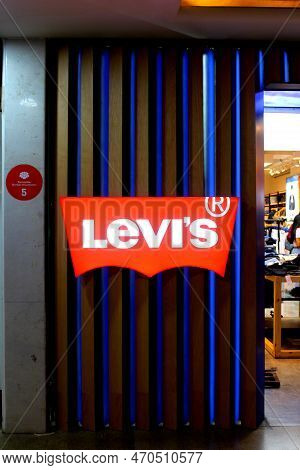 Levis Logo Outside An Outlet In A Mall. Mall Visible On The Right Side. Mannequins Visible With Clot