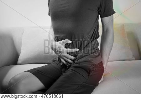 A Man Sitting Farting On The Sofa Because Flatulence.