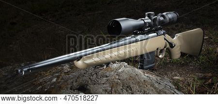 Beige 556 Chambered Bolt Action Rifle With A Scope In The Woods
