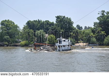 Tigre, Buenos Aires, Argentina, Jan 11 2022: Boat Transporting Debris On The Lujan River