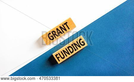 Grant Funding Symbol. Concept Words Grant Funding On Wooden Blocks. Beautiful White And Blue Backgro