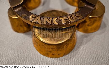 Church Hand Bell For Ringing At Mass And Other Celebrations With A Sign Sanctus. English Translation