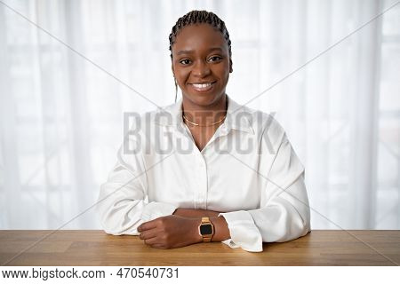 Positive Young Black Woman Sitting At Workdesk At Office