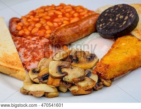 White Board With Full English Breakfast With Bacon, Fried Egg, Beans, Tomato, Roasted Sausage, Black