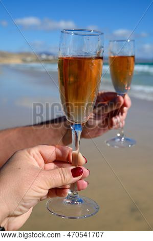 Beach Party, Hands With Glass Of Rose Champagne Or Cava Sparkling Wine, View On White Sandy Tropical