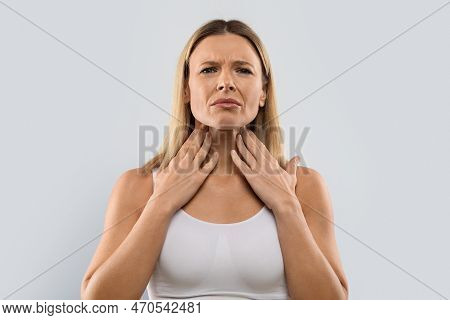 Unhappy Blonde Woman Touching Her Neck, Checking Adenoids