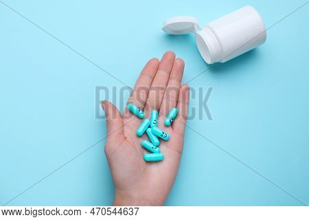 Woman Holding Antidepressants With Different Emoticons On Light Blue Background, Top View