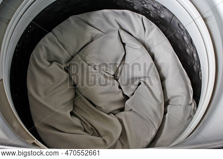 Roll Up The Duvet And Put It In The Washing Machine.for The Presentation Of The Washing Machine.