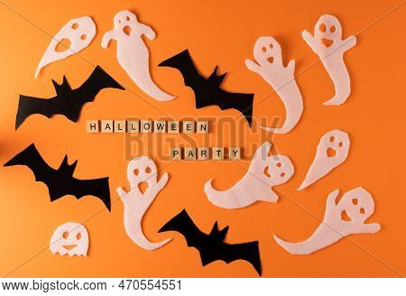 White Ghosts And Bat Craft For Halloween Party. Wrapping Paper Ghost On Orange Background Top View. 