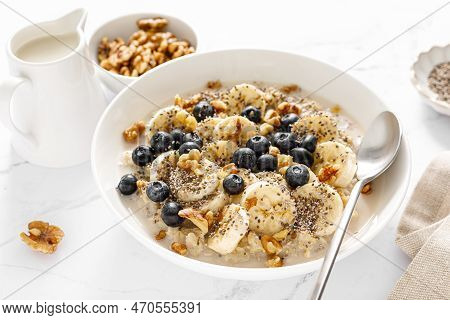 Oatmeal Bowl. Oat Porridge With Banana, Blueberry, Walnut, Chia Seeds And Oat Milk For Healthy Break