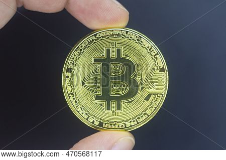 Finger Hold Bitcoin Golden On Black Isolated. Hand Hold Gold Bitcoin Crypto Ditital Money Concept. O