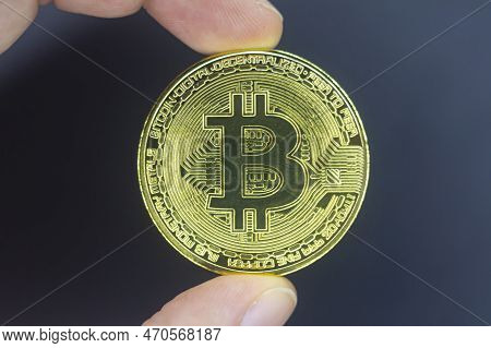 Finger Hold Bitcoin Golden On Black Isolated. Hand Hold Gold Bitcoin Crypto Ditital Money Concept. O