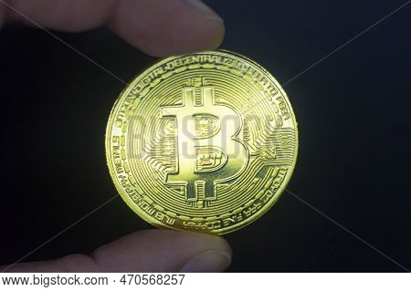 Finger Hold Bitcoin Golden On Black Isolated. Hand Hold Gold Bitcoin Crypto Ditital Money Concept. O