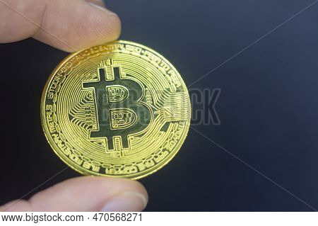 Finger Hold Bitcoin Golden On Black Isolated. Hand Hold Gold Bitcoin Crypto Ditital Money Concept. O