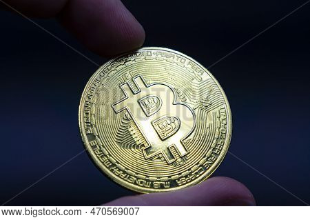 Finger Hold Bitcoin Golden On Black Isolated. Hand Hold Gold Bitcoin Crypto Ditital Money Concept. O