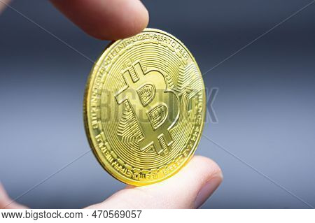 Finger Hold Bitcoin Golden On Black Isolated. Hand Hold Gold Bitcoin Crypto Ditital Money Concept. O