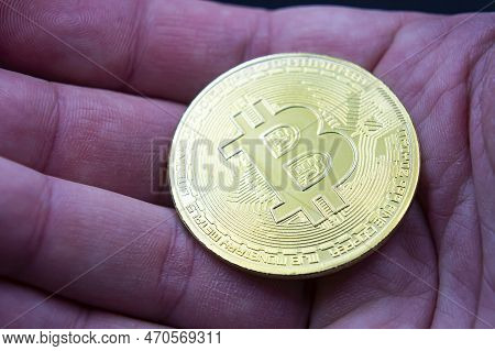 Finger Hold Bitcoin Golden On Black Isolated. Hand Hold Gold Bitcoin Crypto Ditital Money Concept. O