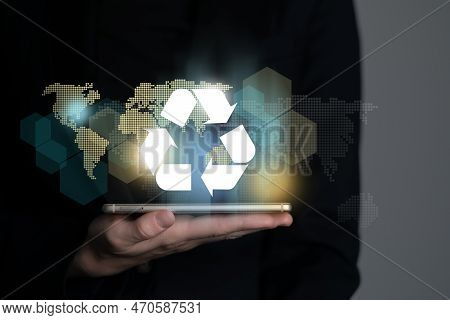 Hand Holding Recycle Symbol On A Screen Of Mobile Phone. Mobile Applications As Asource Of Informati