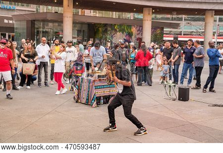 Toronto, Canada - 07 01 2022: Street Musician Playing Pan Flute In A Circle Of Spectators On Yonge-d